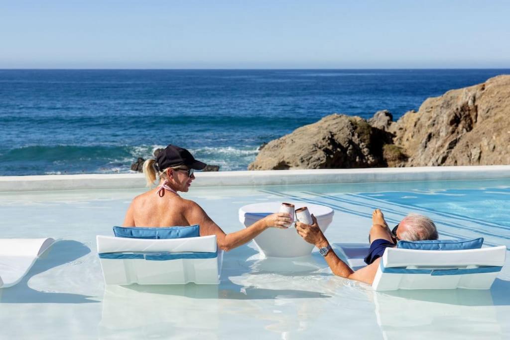 Un uomo e una donna seduti in acqua di Modern Beachfront Residence with Resort Amenities a El Pescadero