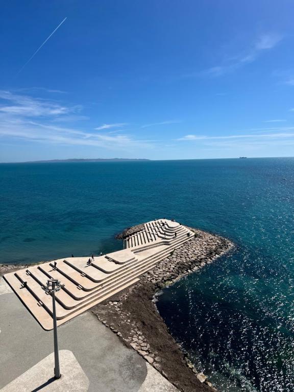 a bench sitting on the edge of the ocean at Sea View Apartments in Durrës