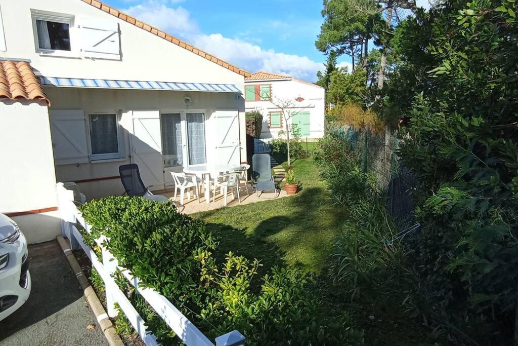 l'arrière-cour d'une maison blanche avec une clôture blanche dans l'établissement La Grière résidence avec piscine, à La Tranche-sur-Mer