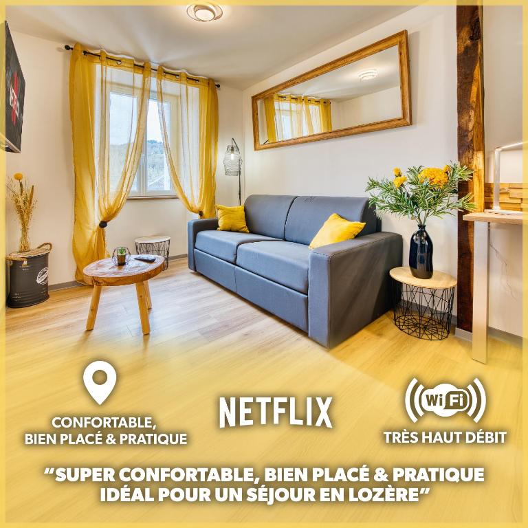 un salon avec un canapé bleu et une table dans l'établissement Les Hourtous Netflix Wi-Fi Fibre Terasse 4 pers, à Banassac