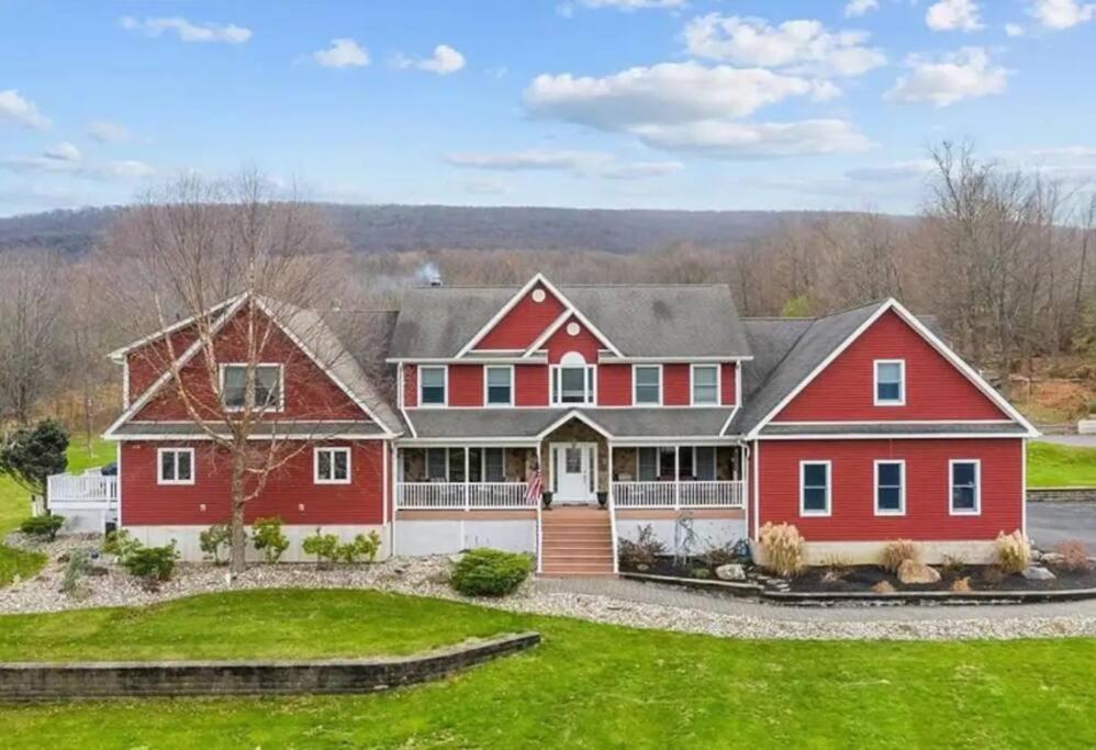 a large red house with a yard at Estate with pool on 11 beautiful acres in Monroe