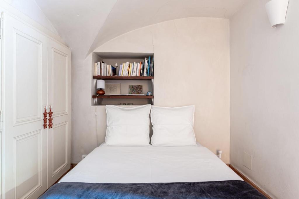 a bedroom with a bed with white sheets and a book shelf at Bed end breakfast du centre in Bourg-Saint-Maurice