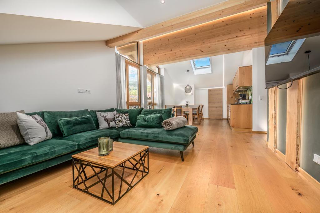 ein Wohnzimmer mit einem grünen Sofa und einem Tisch in der Unterkunft Schmuckstück Ferienapartments Bodenmais in Bodenmais
