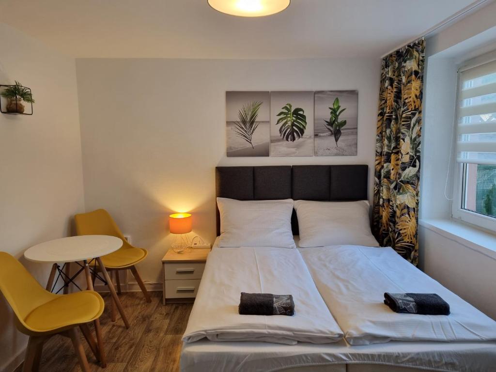 1 dormitorio con 1 cama, mesa y sillas en Pokoje goscinne Gala, en Międzyzdroje