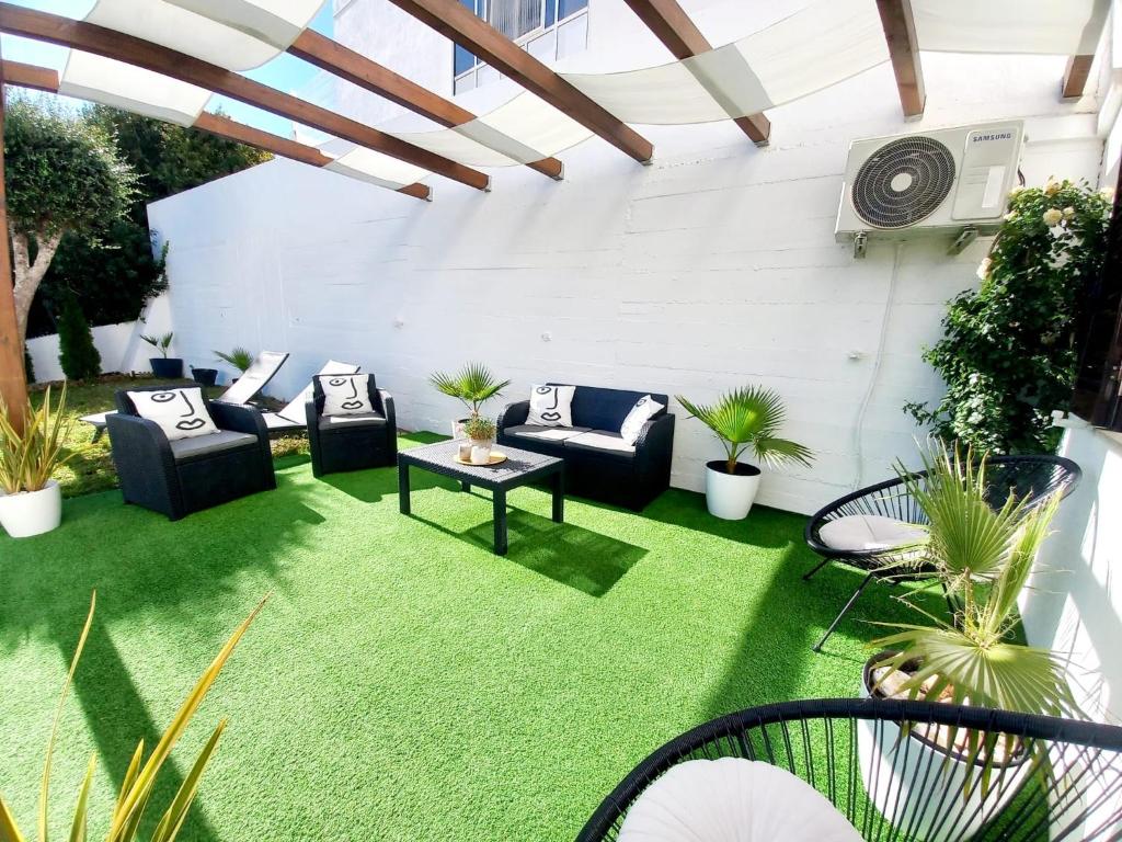 a patio with grass and couches and plants at Feliz Algarve in Albufeira