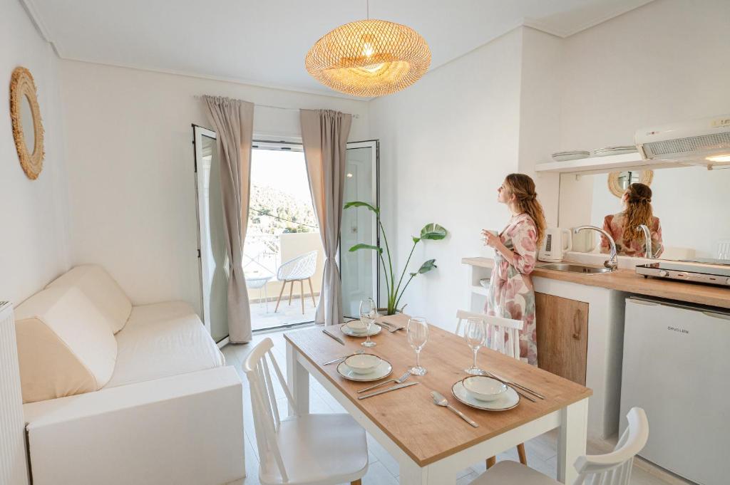 dwie kobiety w kuchni i stół w pokoju w obiekcie The White Rose Hotel w Poros