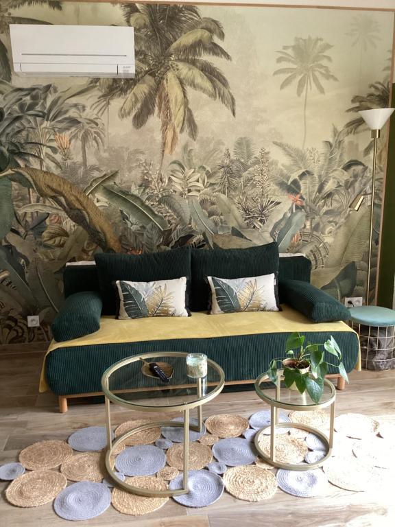 uma sala de estar com um sofá verde e um mural de palma em Guest house arboré em Saint-Loubès