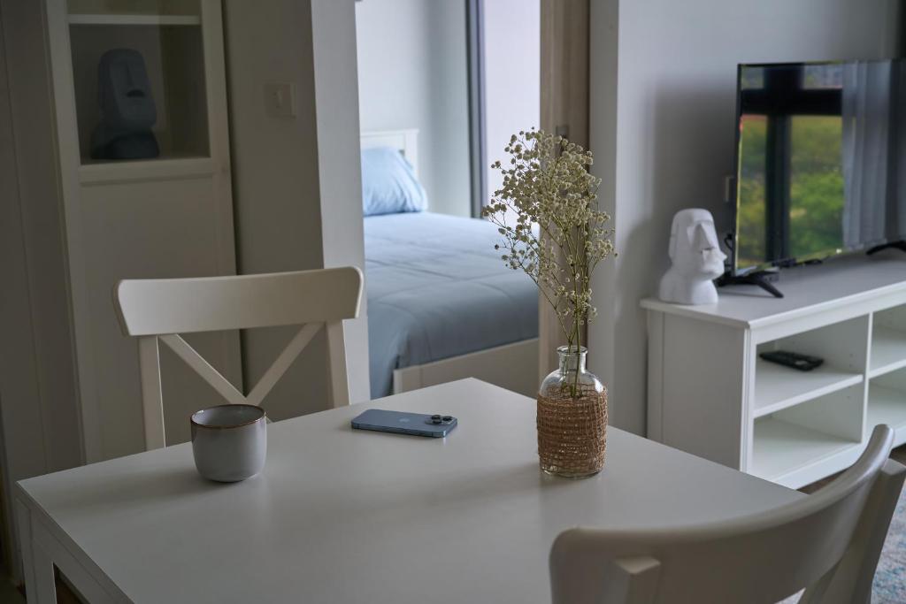 um quarto com uma mesa com um vaso de flores em Modern 2-bedroom Apartments. Skypark Laguna (Bang Tao) em Praia de Bang Tao