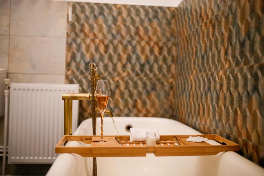 bañera con copa de vino y botella de champán en Joseph Hayn Apartments, en Sighişoara