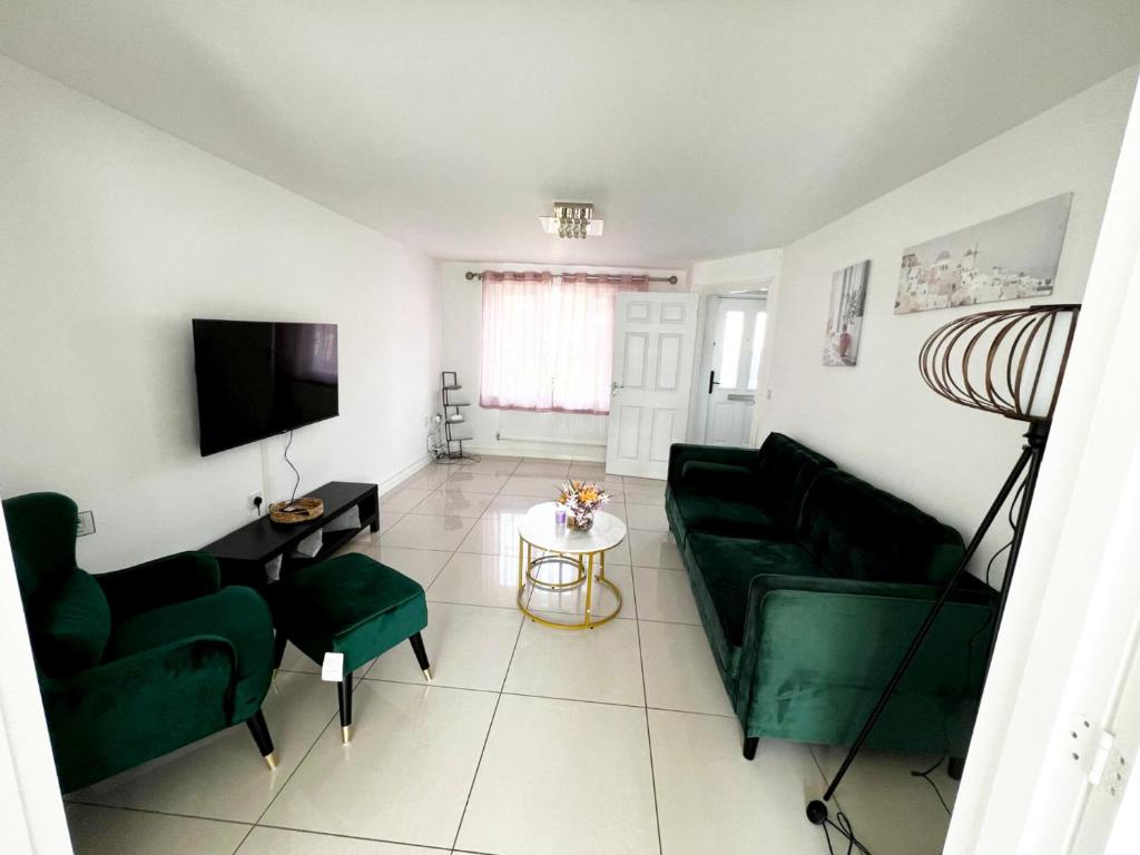 uma sala de estar com um sofá verde e uma mesa em Spacious Modern 4BD House em Hull