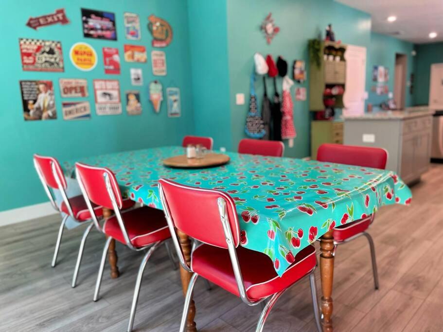 uma mesa de jantar com cadeiras vermelhas e uma toalha de mesa verde em The Sanford Bandstand em Sanford