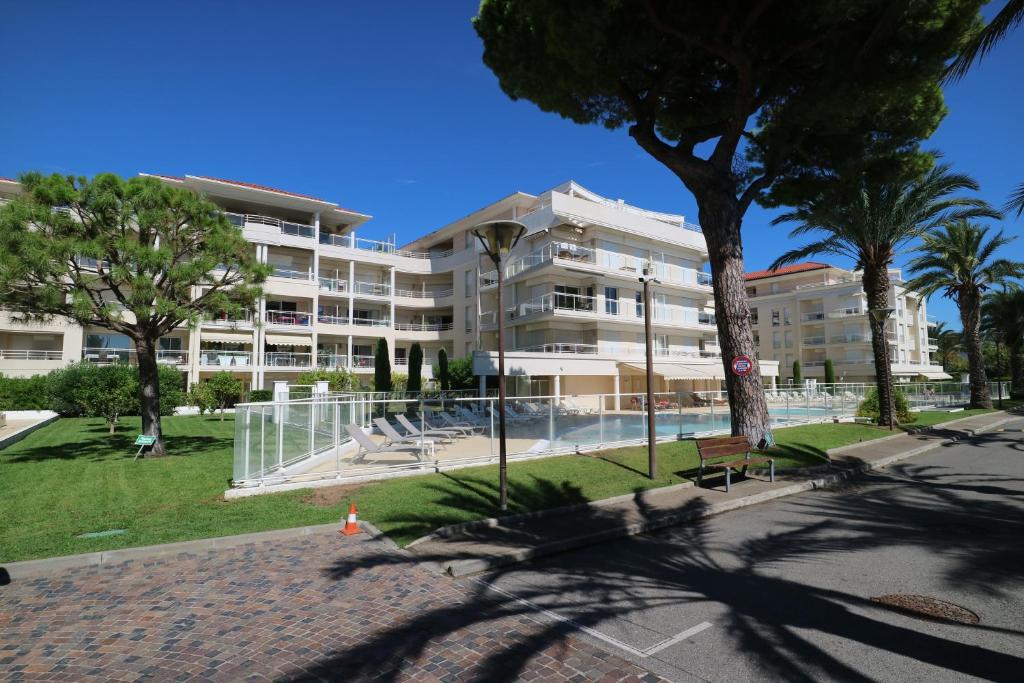 un grand bâtiment avec des palmiers devant dans l'établissement Ocean View Royal Palm, à Cannes