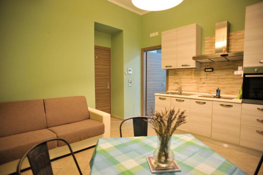 sala de estar con sofá y mesa en la cocina en In Center apartaments, en Salerno