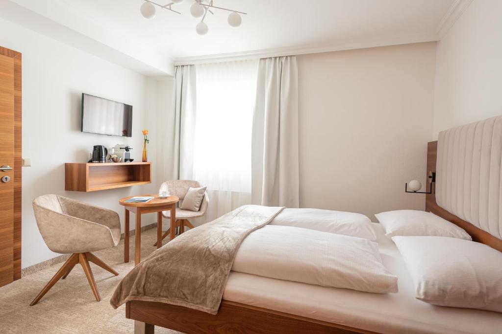 um quarto com uma cama, uma mesa e uma cadeira em das zellersee em Zell am See