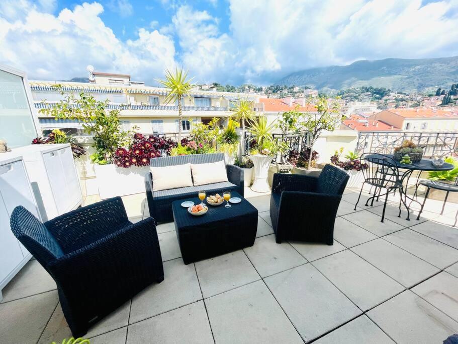 d'une terrasse avec des canapés et une table sur un balcon. dans l'établissement Le Victoria Beach, beau T2 à 1 minute des plages, à Menton
