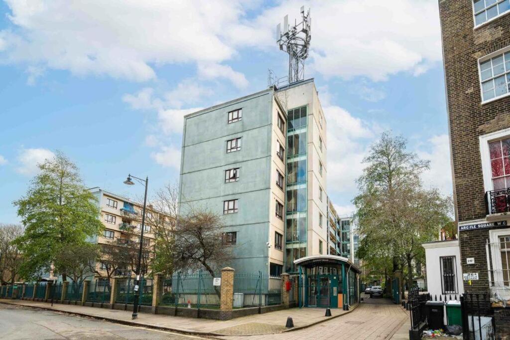 a tall building with a antenna on top of it at Sandfield Private Rooms in King's Cross St Pancrass in London