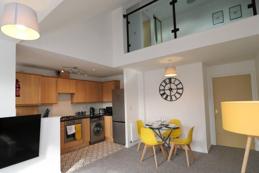 a kitchen with a dining table and yellow chairs at 2 Bedroom Penthouse in Coventry - Private Parking in Coventry