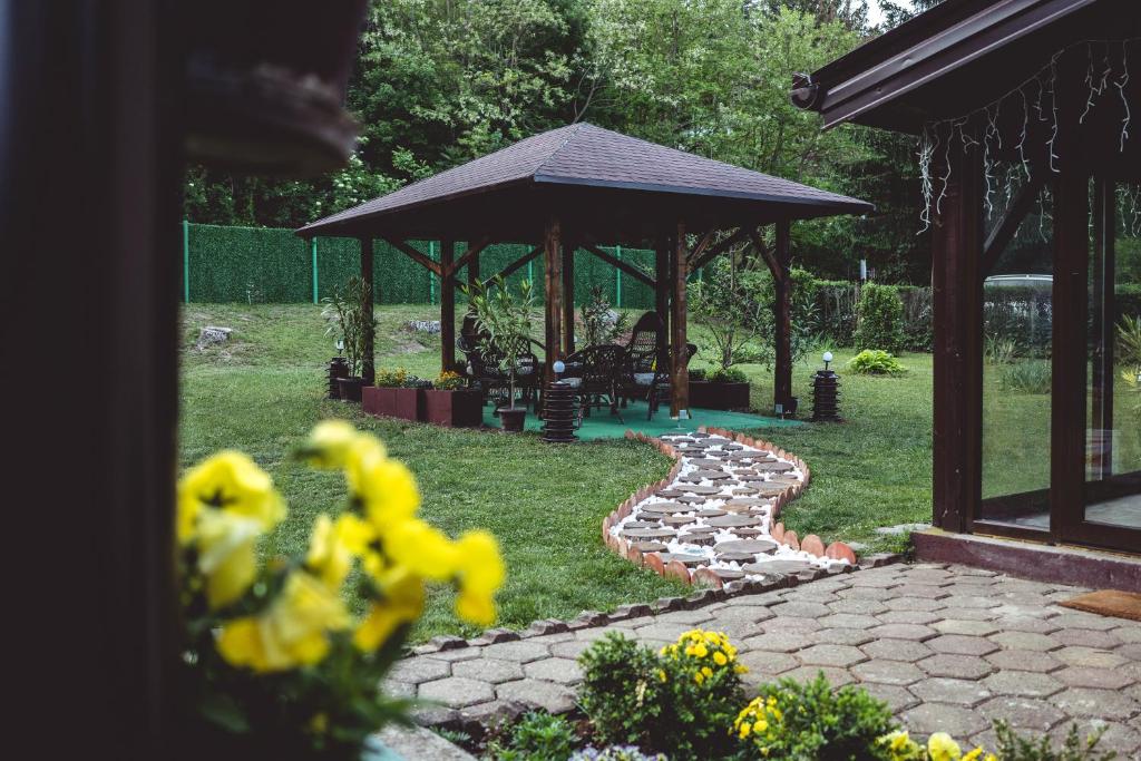 um jardim com um gazebo e um caminho de pedra em Vikendica Fruškogorski kutak - Fruška Gora em Čerević
