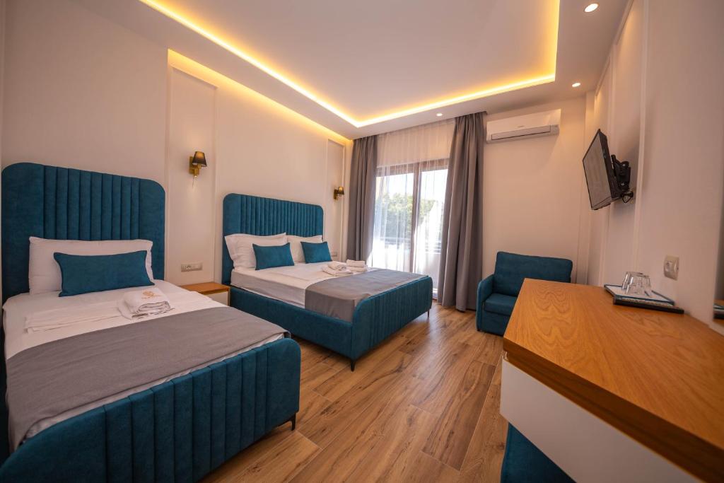 Habitación de hotel con 2 camas y escritorio en Hotel Vila Misiri en Durrës