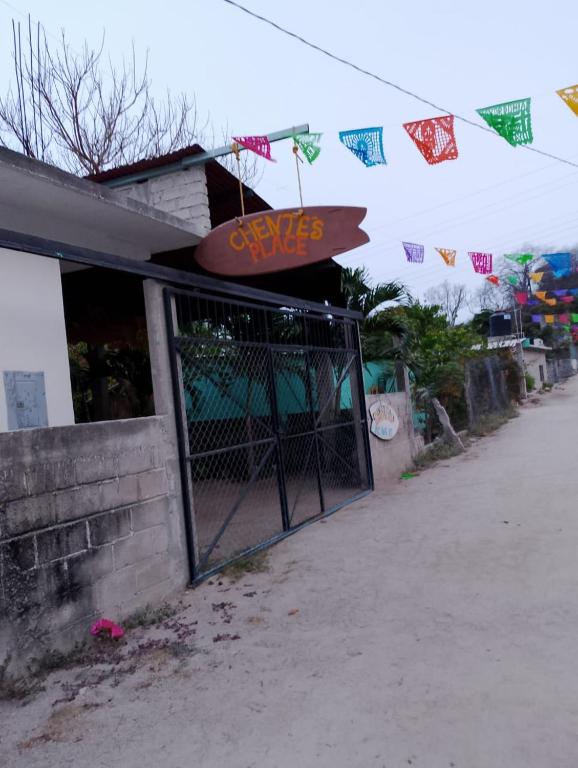 a building with a gate with a sign on it at Chentes Place in Barra de la Cruz
