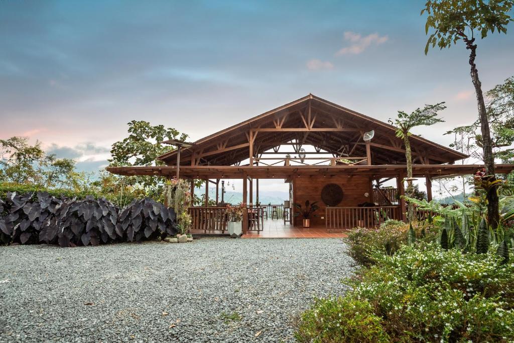 un grand bâtiment en bois avec un toit dans l'établissement Tominejo Ecolodge Casas en los árboles, à Neira