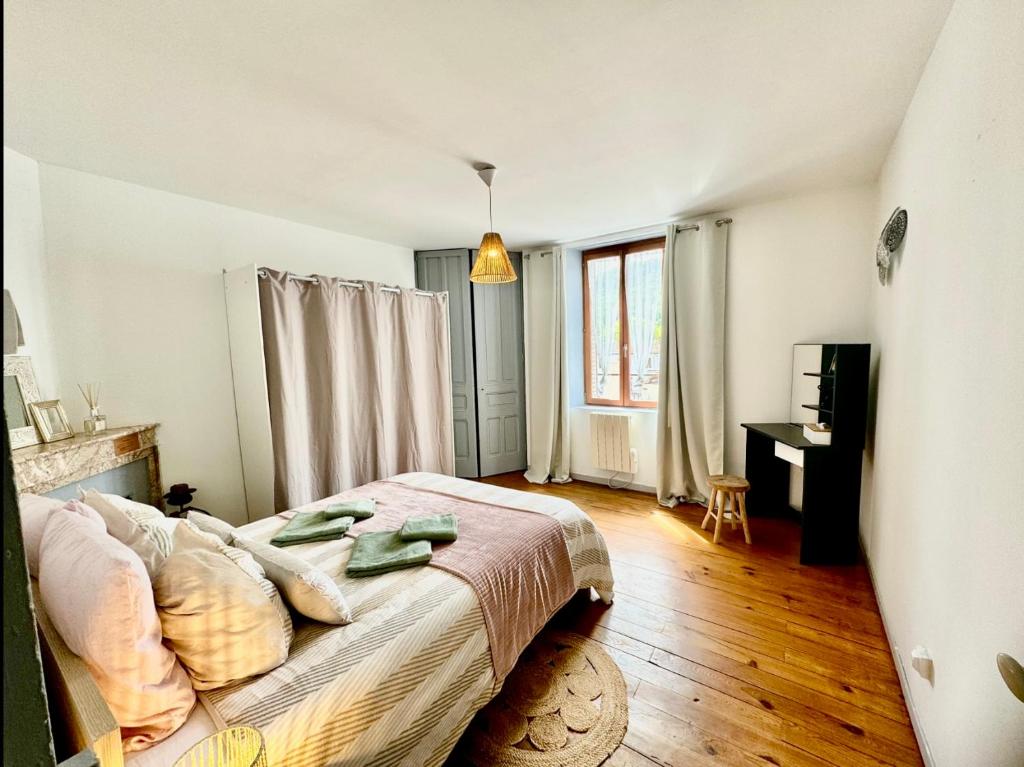 een slaapkamer met een bed, een bureau en een raam bij Apartment La Viarhôna à Brégnier-Cordon in Brégnier-Cordon