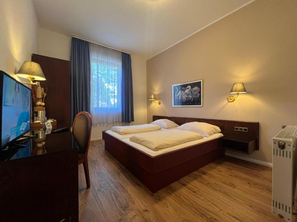 a bedroom with a bed and a flat screen tv at Central Hotel in Worms