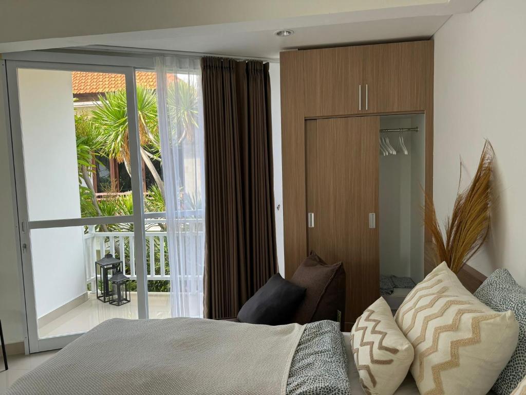 a bedroom with a bed and a sliding glass door at Homely, Cozy Studio in Seminyak 5 in Seminyak