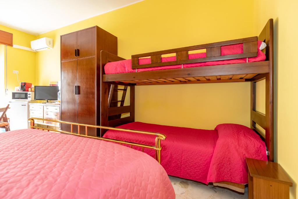 - une chambre avec 2 lits superposés et des draps rouges dans l'établissement Casa Ai Cappuccini, à Randazzo