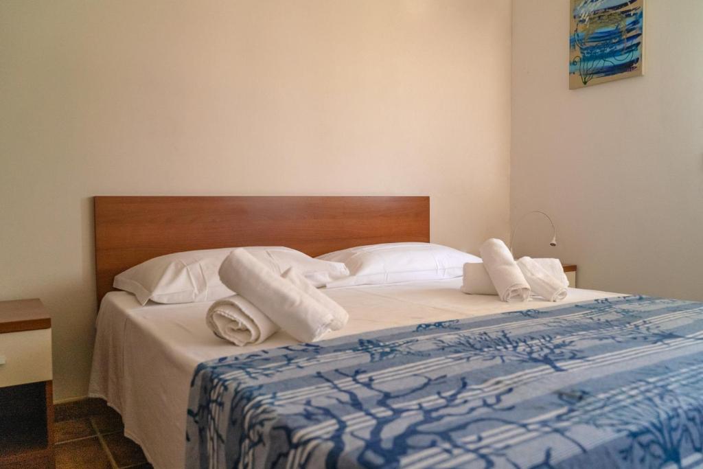 een slaapkamer met een bed met witte lakens en kussens bij Agua Residence in Noto