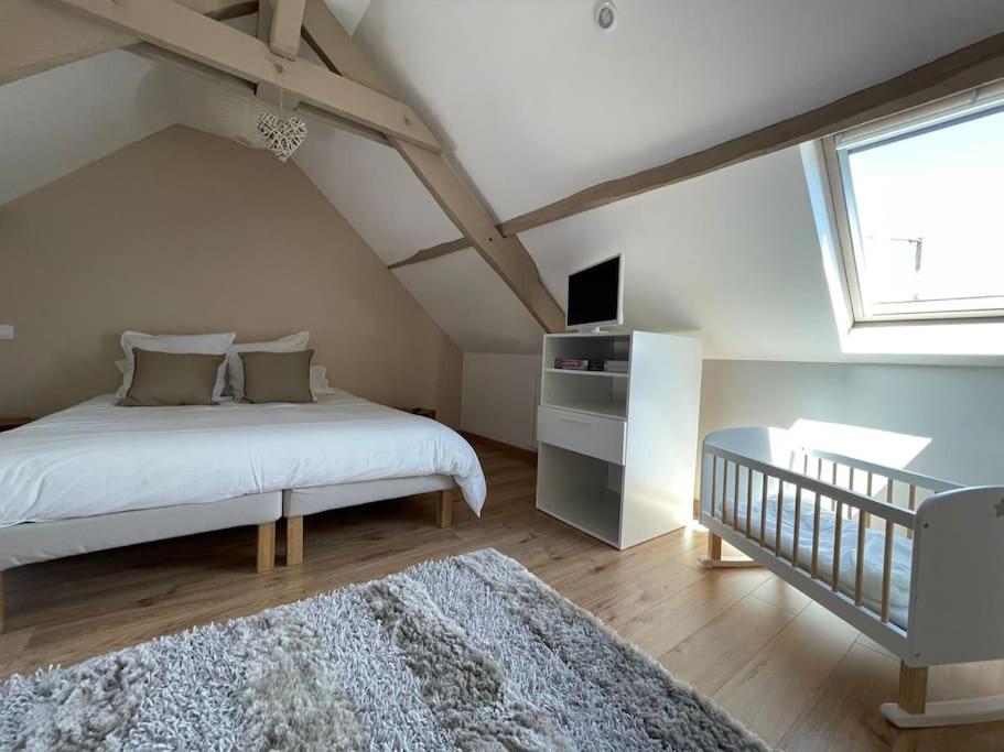 une chambre avec un lit blanc et une fenêtre dans l'établissement Maison de famille avec SPA, à Clécy