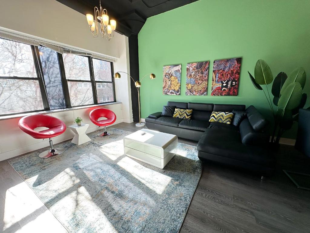 a living room with a black couch and a red chair at McCormick Place spacious 3br-2ba designer suite with optional parking for 8 guests in Chicago