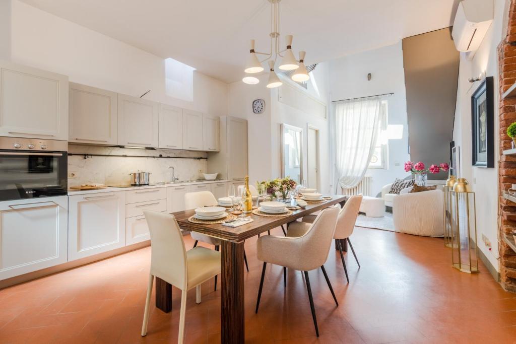 a kitchen and dining room with a table and chairs at Georgia Modern Panoramic Penthouse with Elevator in Lucca