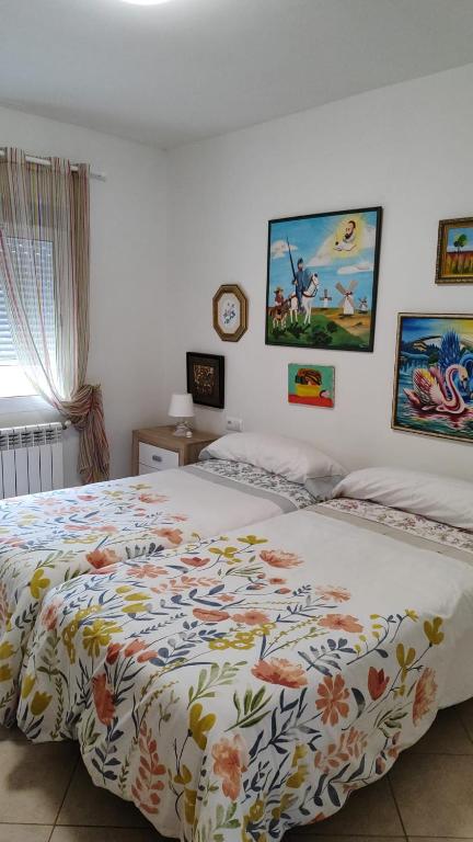 sypialnia z łóżkiem z narzutą w kwiaty w obiekcie Casa de campo tranquila en vilar cerca de santiago w mieście Touro