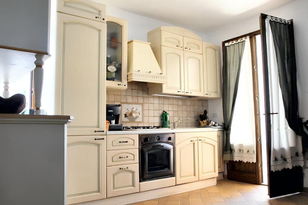 una cucina con armadietti bianchi e piano cottura di 2 bedrooms house at Calasetta 400 m away from the beach with enclosed garden a Calasetta