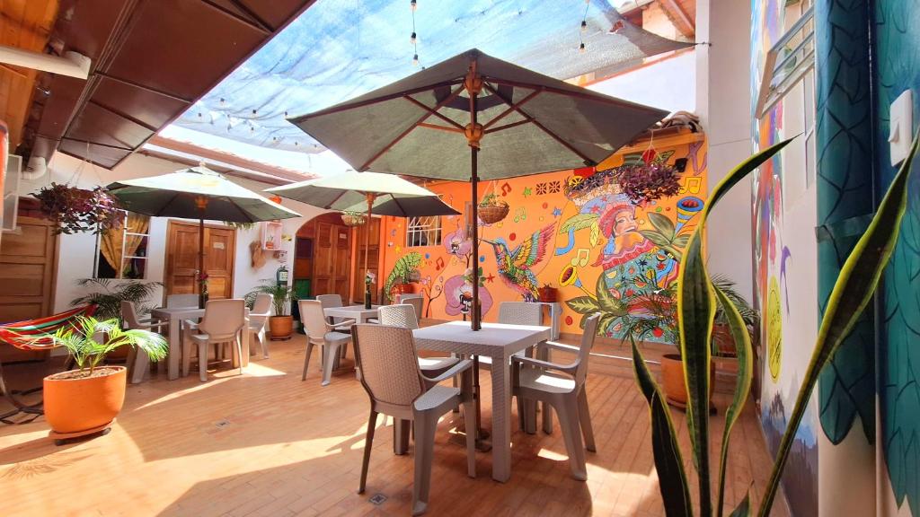 een restaurant met tafels en stoelen en een parasol bij Hostal Colombian Gold in San Gil