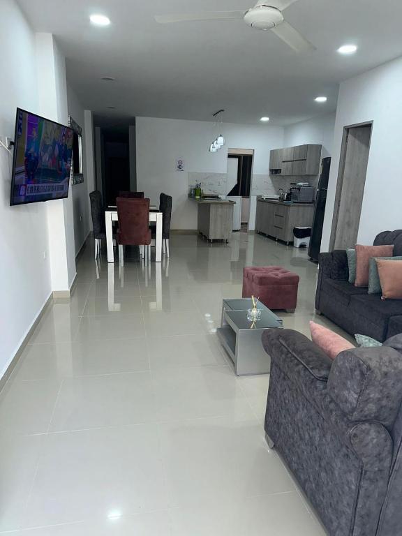a living room with couches and a table and a kitchen at Espectacular apartamento central in Montería