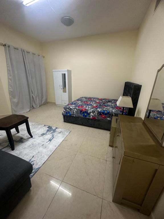 - une chambre avec un lit et un bureau dans l'établissement Premium Furnished Rooms Your Perfect Stay, à Ajman