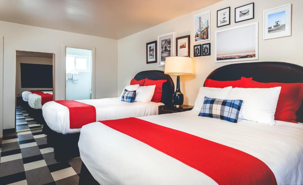 two beds in a hotel room with red and white at LiA Hotel in San Carlos