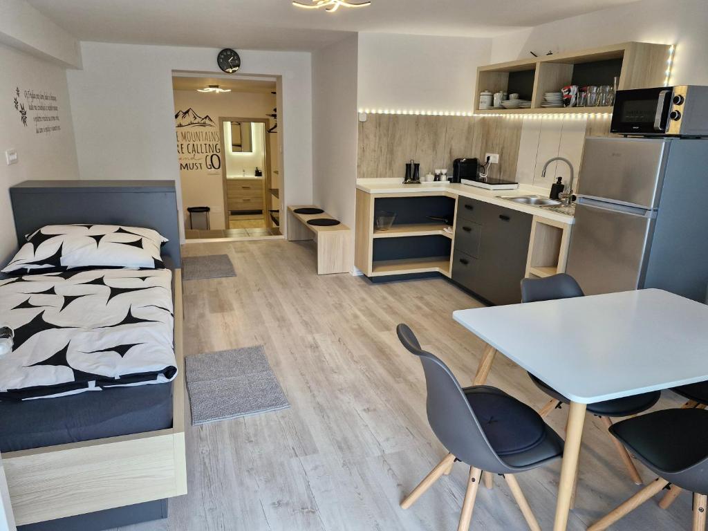 1 dormitorio con 1 cama, mesa y sillas en Apartma Vovk, en Mojstrana