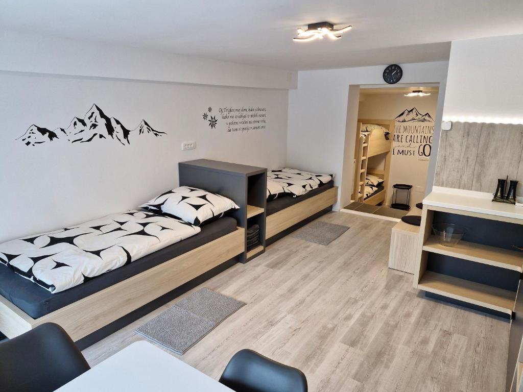 um quarto com duas camas e uma mesa e cadeiras em Apartma Vovk em Mojstrana