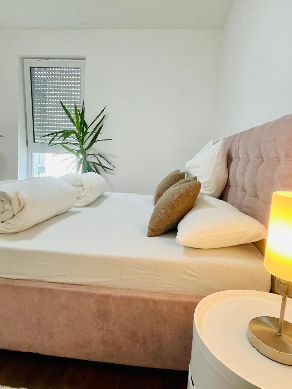 a bed in a room with a couch and pillows at Moderne Wohnung 100 m2 mit Büro und Terrasse in Mühldorf