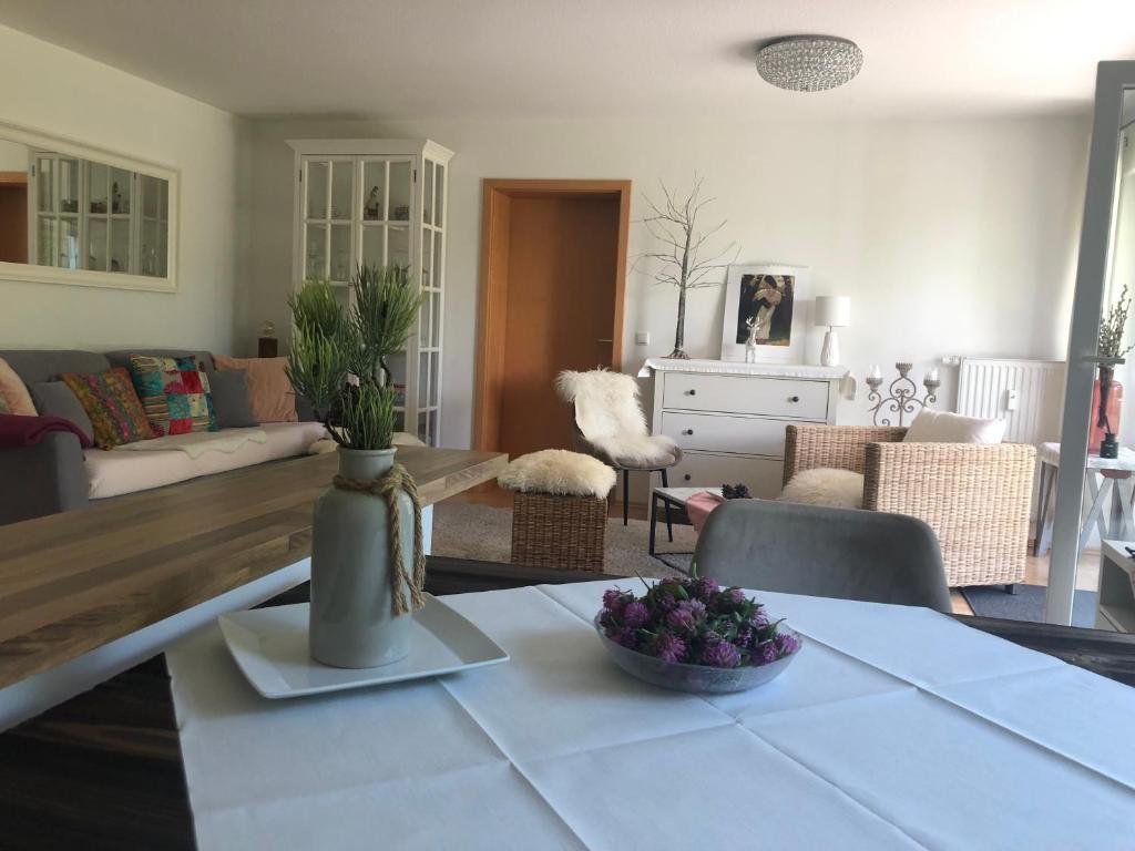 una sala de estar con una mesa con un jarrón. en Auszeit im Allgäu en Sonthofen