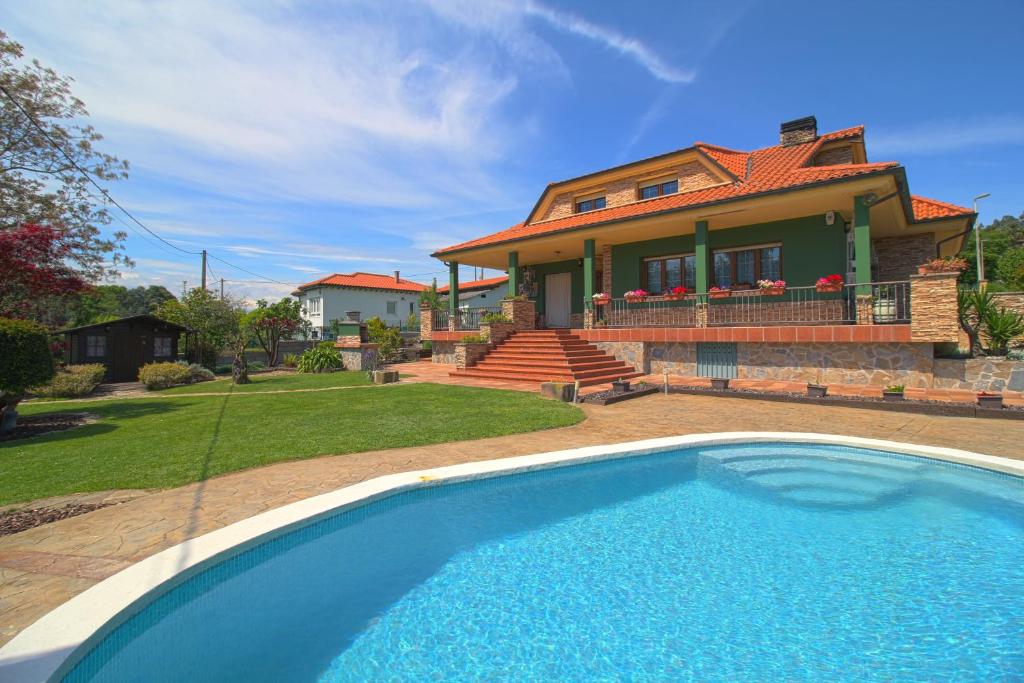una casa con piscina frente a una casa en Green House en Reocín