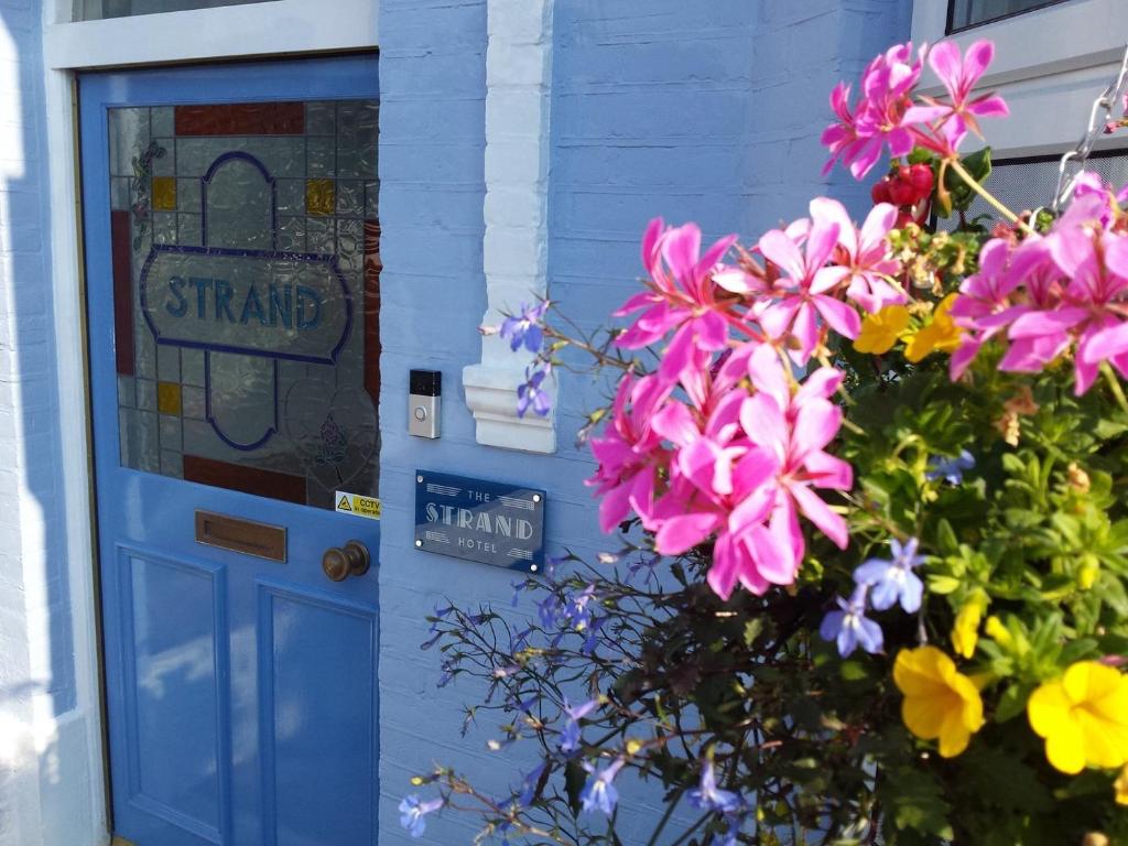 a blue door with flowers in front of a house at The Strand Hotel in Bournemouth