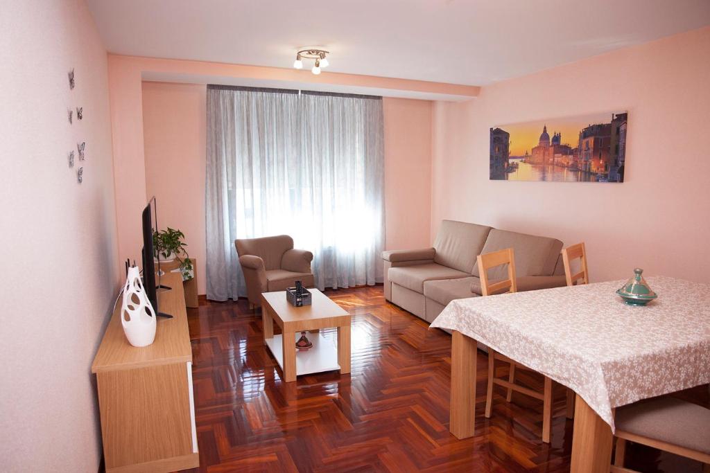 - un salon avec un canapé et une table dans l'établissement Laros Pios Alojamiento, à Villalba