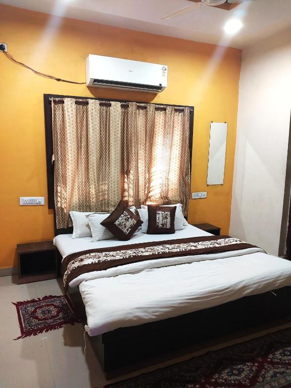 - une chambre avec un grand lit et une fenêtre dans l'établissement Hotel Parth Inn (Lodge), à Wardha