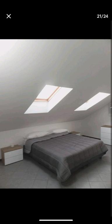 - une chambre avec un lit dans une pièce dotée de lucarnes dans l'établissement Suite Room Malpensa apartment, à Cardano al Campo
