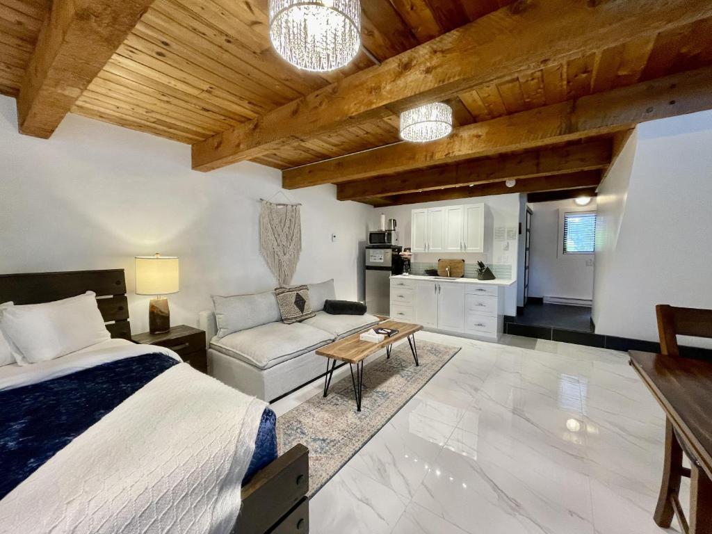 1 dormitorio con cama, sofá y mesa en Waterfront Hot Tub Firepit King Bed - 6h, en Ucluelet