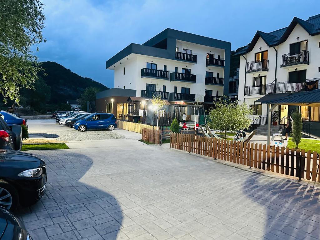 a parking lot with cars parked in front of a building at GRAND Caciulata in Caciulata